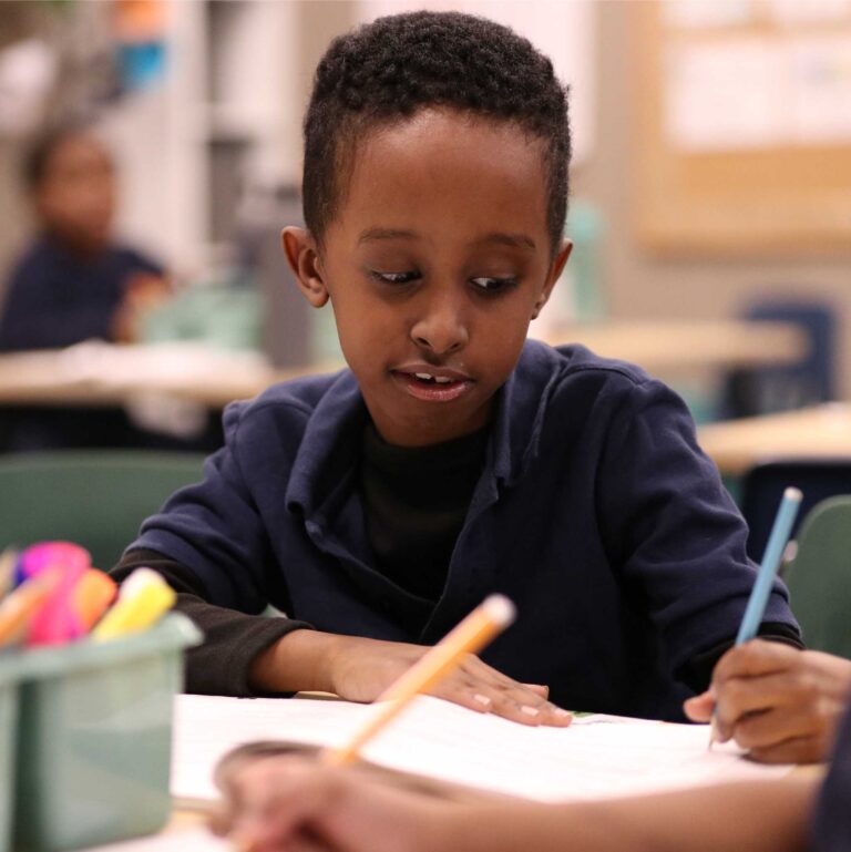 NECP student writing in a notebook